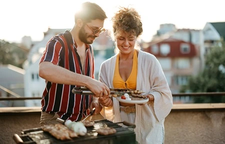 Freunde, die auf einem Balkon grillen
