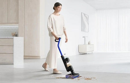 femme qui passe aspirateur dans sa cuisine